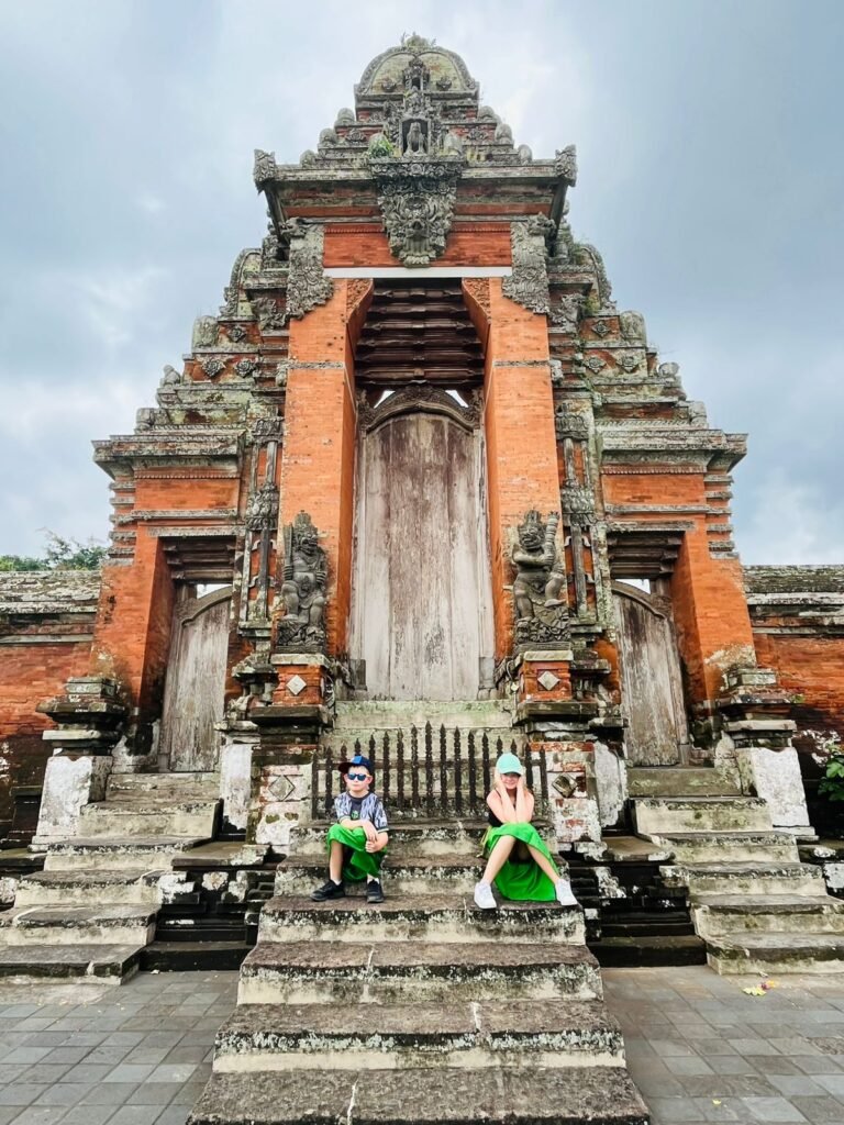 Visitors at a tall carved Balinese temple gate